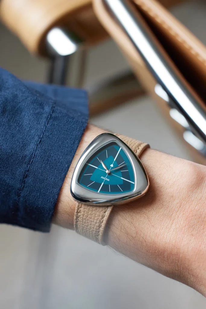 Anoma A1 am Handgelenk getragen: Skulpturale Designeruhr mit weichem Dreiecksgehäuse und minimalistischem Zifferblatt, perfekt für moderne Eleganz.