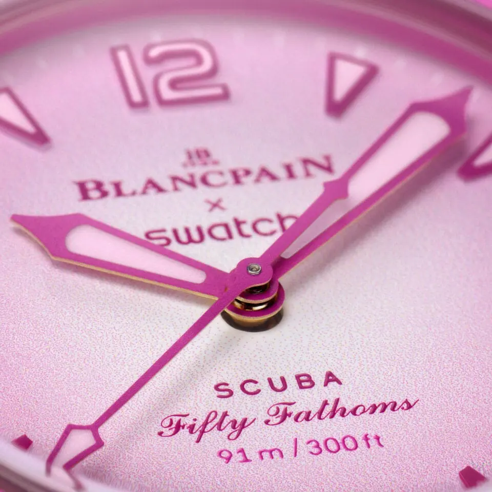 Detailaufnahme des Zifferblatts der Swatch x Blancpain Scuba Fifty Fathoms Pink Ocean mit klar ablesbaren Indizes.