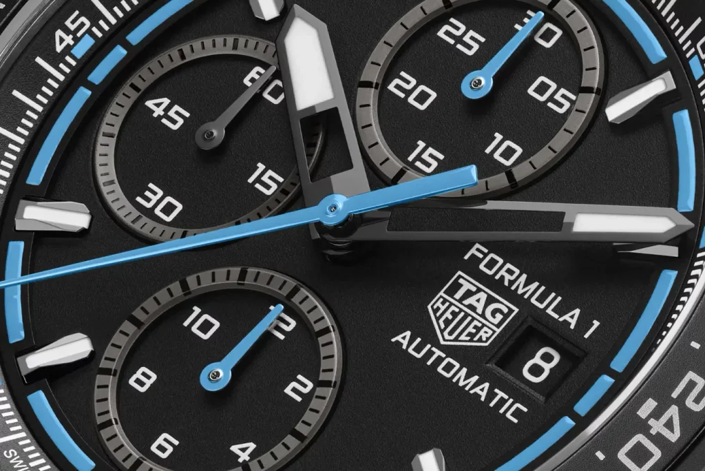 Nahaufnahme des Zifferblatts des TAG Heuer Formula 1 Chronographen mit blauem Rand, mit Fokus auf die Chronographenanzeigen und die feinen Details des Designs.
