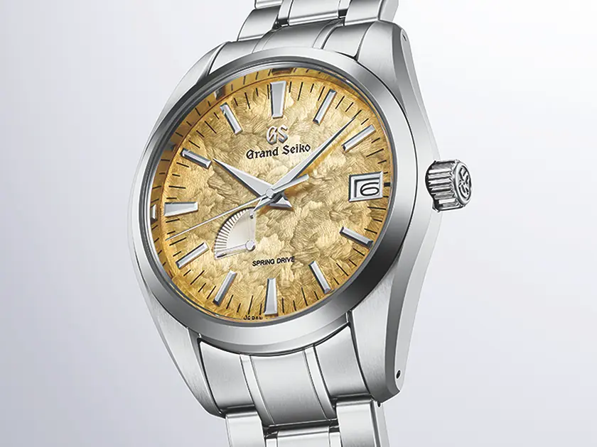 Nahaufnahme der Lünette und des Zifferblatts der Grand Seiko SBGA503 Ginza, mit filigranem Muster und Gangreserveanzeige.