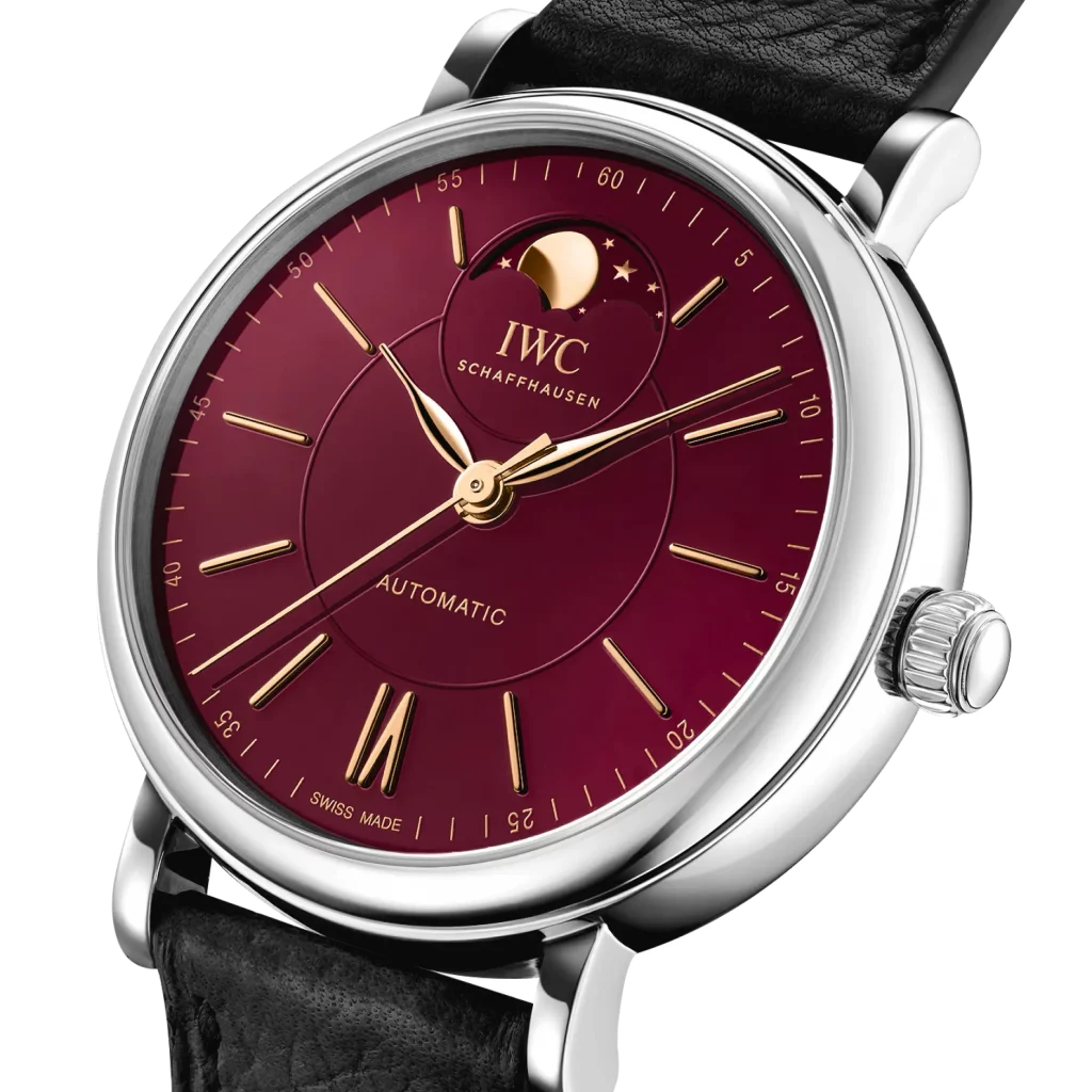 Detailansicht des bordeauxroten Zifferblatts der IWC Portofino 37 mit vergoldeten Indizes und Mondphasenanzeige.