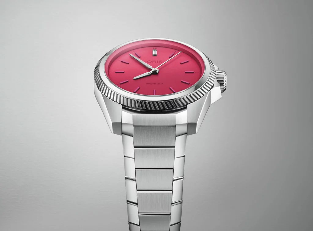 Die Oris ProPilot X Miss Piggy Edition, leicht von unten fotografiert, mit Fokus auf das lebendige pinke Zifferblatt.
