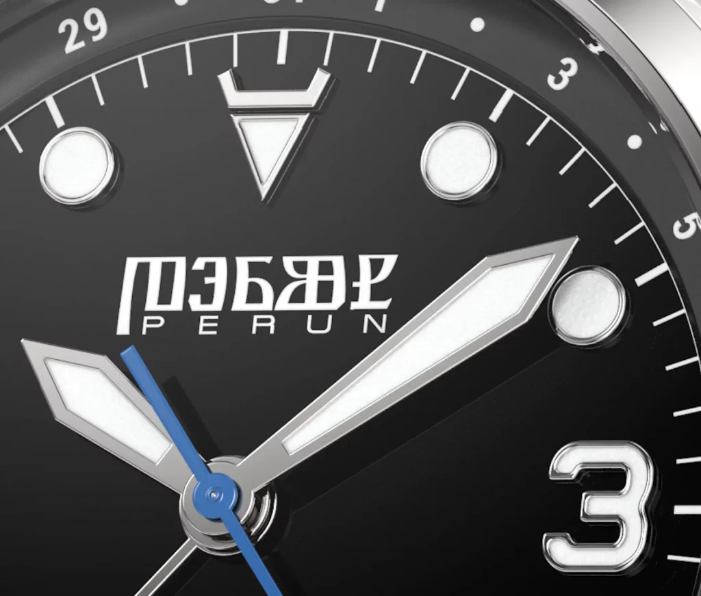 Nahaufnahme des emaillierten Zifferblatts der Perun Veles in Perlweiß, mit slawischen Symbolen und filigranen Zeigern.